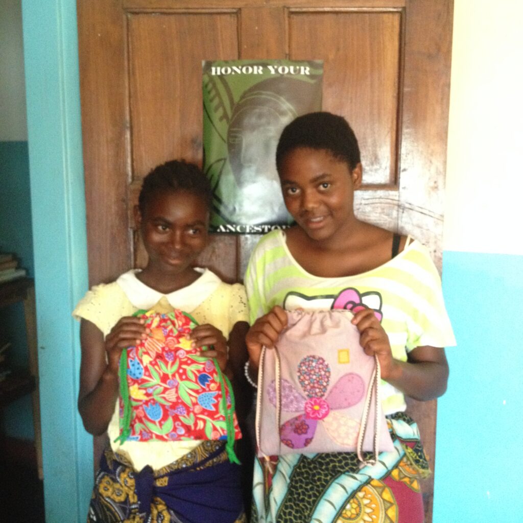 Two girls holding handmade bags